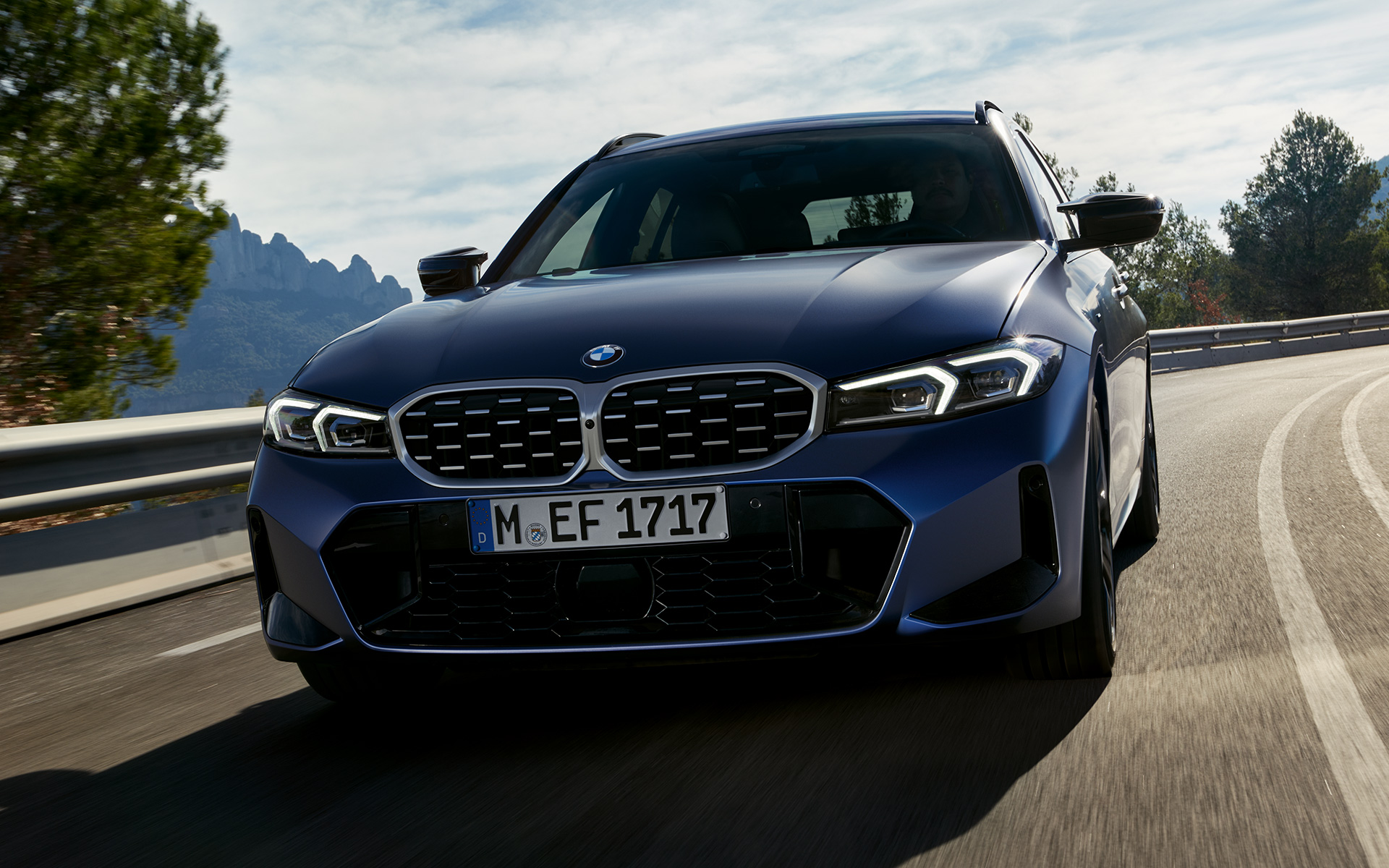 BMW M340i xDrive Touring G21 у кольорі Frozen Tanzanite Blue, вид спереду в русі на вулиці