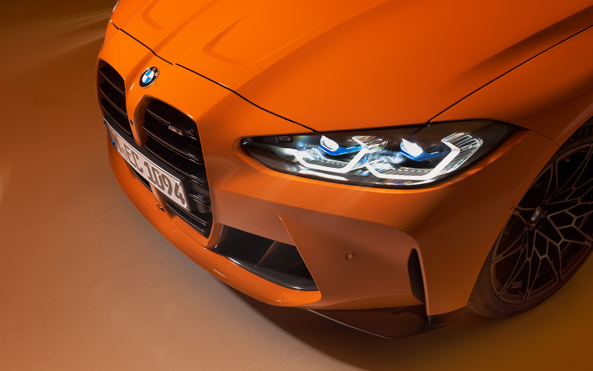 BMW M4 Competition Coupé G82 2021 BMW Individual Fire Orange вид спереду в три чверті великим планом з видом зверху